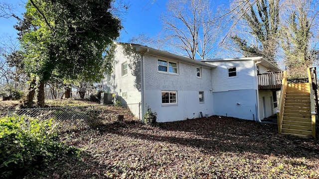 back of house with a wooden deck and central AC