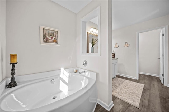 bathroom with hardwood / wood-style flooring, a bathtub, and vanity