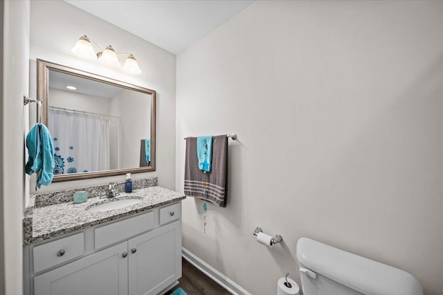 bathroom with vanity, toilet, hardwood / wood-style floors, and a shower with curtain