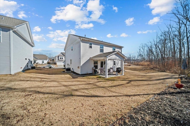 rear view of house with a lawn, a patio, and central AC