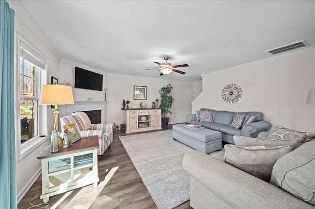 living room featuring hardwood / wood-style flooring, crown molding, and ceiling fan