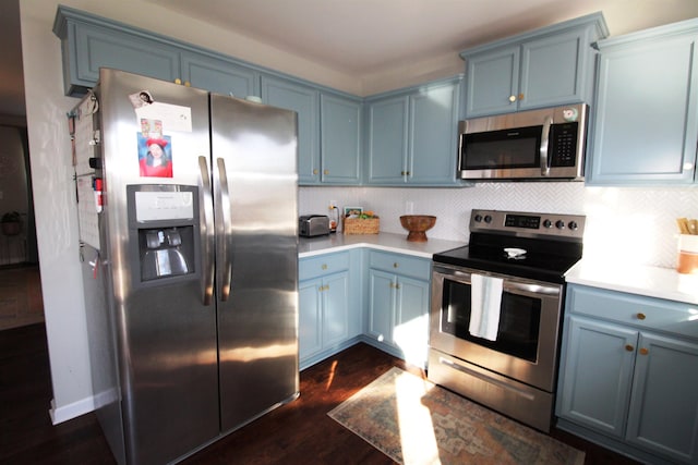 kitchen with backsplash, dark hardwood / wood-style flooring, blue cabinets, and appliances with stainless steel finishes