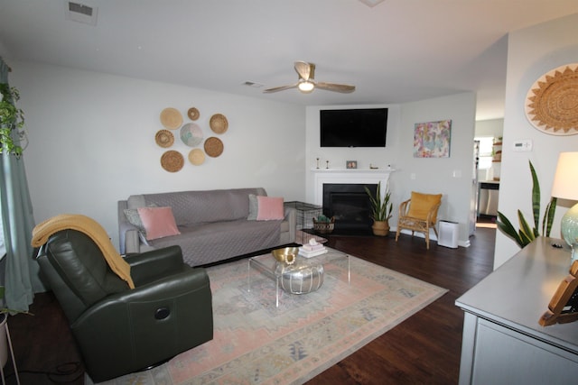 living room featuring ceiling fan and dark hardwood / wood-style flooring