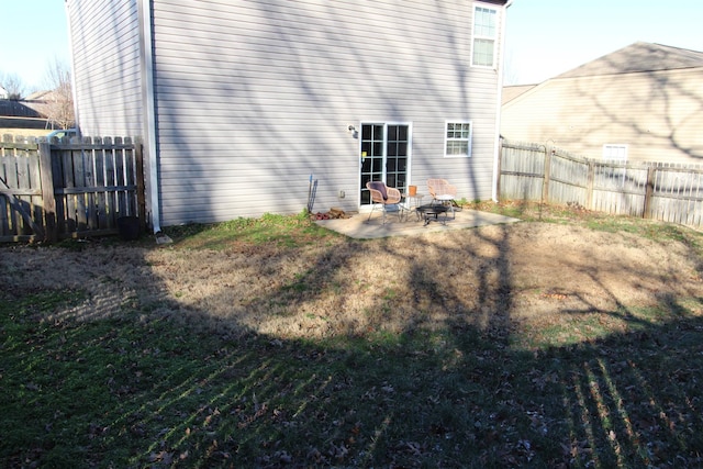 rear view of house with an outdoor fire pit, a patio, and a yard