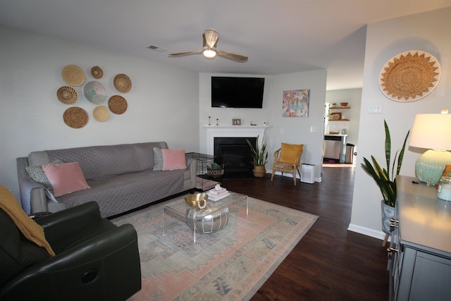 living room with ceiling fan and dark wood-type flooring