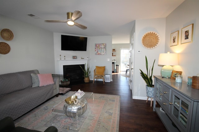 living room with ceiling fan and dark hardwood / wood-style flooring