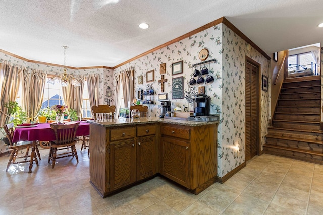 kitchen featuring ornamental molding, pendant lighting, and a textured ceiling