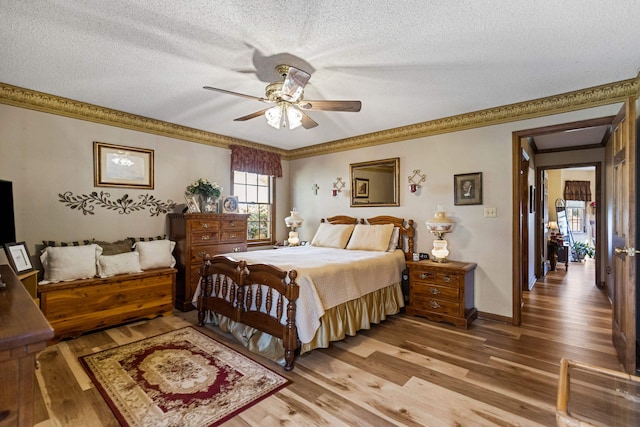 bedroom with ceiling fan, ornamental molding, hardwood / wood-style floors, and a textured ceiling