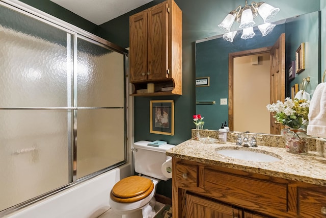 full bathroom with an inviting chandelier, vanity, shower / bath combination with glass door, and toilet