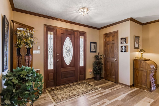 entryway with ornamental molding, light hardwood / wood-style floors, and a textured ceiling