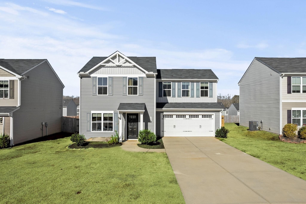 front facade with a front yard, central AC unit, and a garage