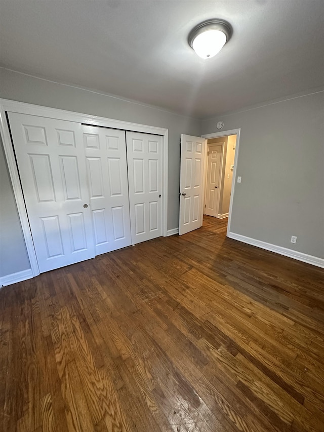 unfurnished bedroom featuring a closet and dark hardwood / wood-style flooring