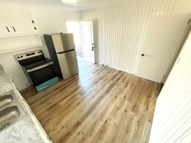 kitchen featuring white cabinets, stainless steel appliances, light hardwood / wood-style flooring, and sink