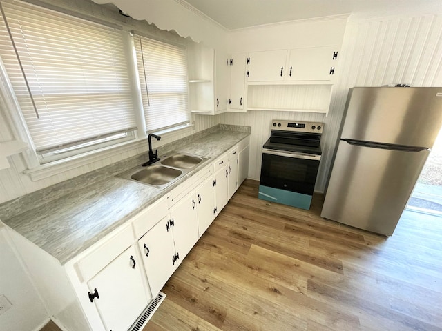 kitchen with crown molding, white cabinets, sink, light hardwood / wood-style flooring, and stainless steel appliances