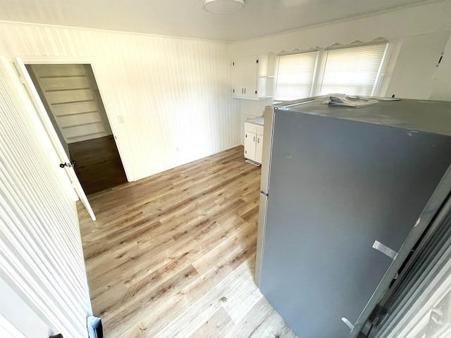 kitchen with white cabinetry, light wood-type flooring, and stainless steel refrigerator