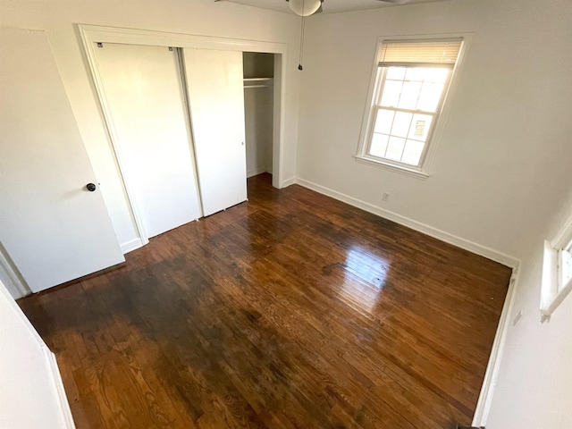 unfurnished bedroom with a closet and dark hardwood / wood-style flooring