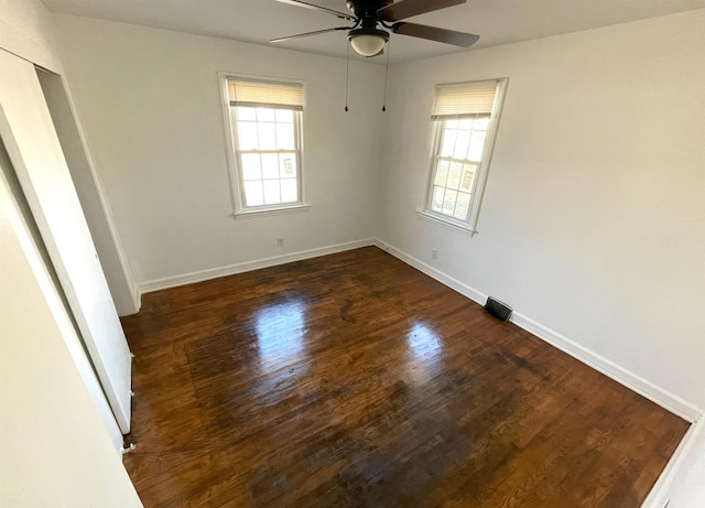 spare room with dark hardwood / wood-style floors and ceiling fan