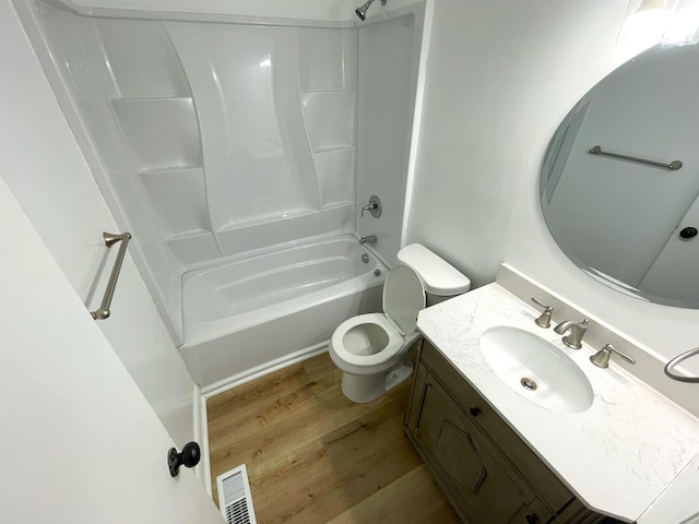 full bathroom featuring hardwood / wood-style flooring, toilet, vanity, and washtub / shower combination