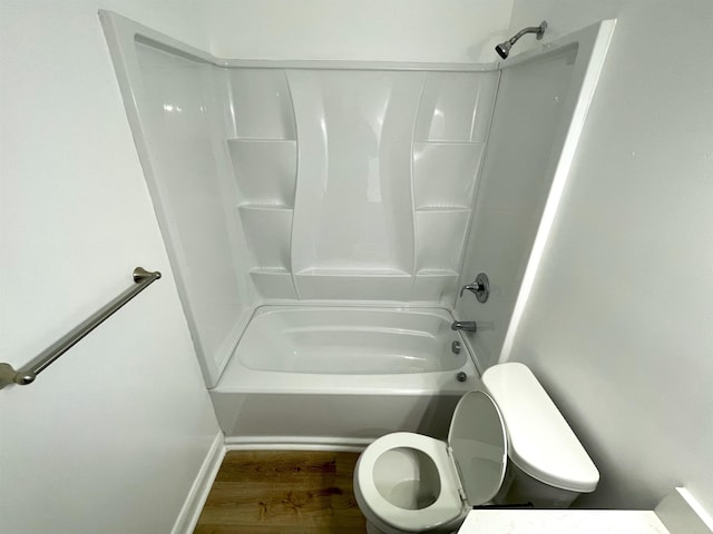 bathroom with toilet, hardwood / wood-style floors, and washtub / shower combination