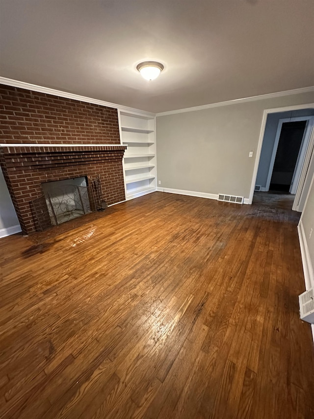 unfurnished living room with dark wood-type flooring, built in features, ornamental molding, and a fireplace