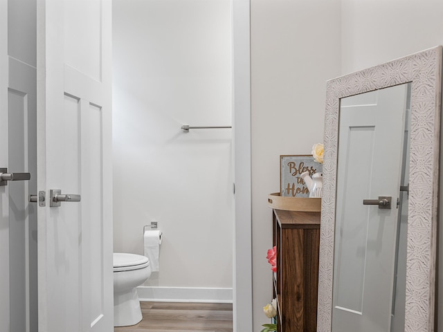 bathroom featuring hardwood / wood-style flooring and toilet