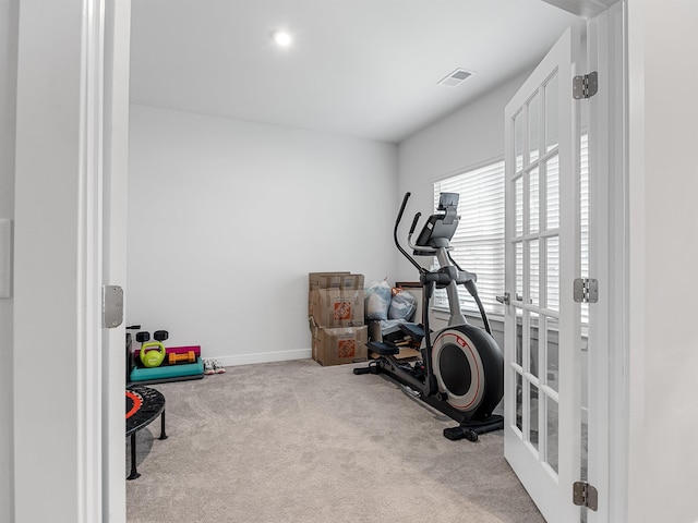 exercise area featuring light colored carpet and french doors