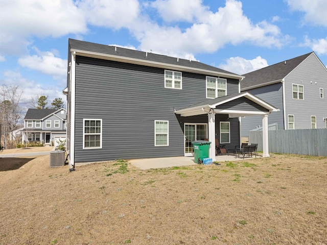 back of property with a patio, a lawn, and central AC