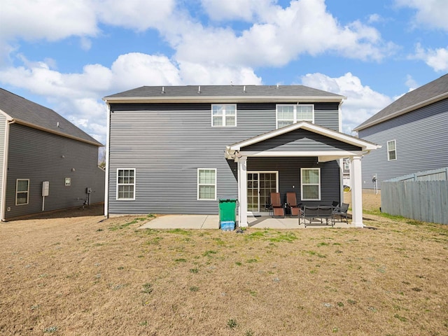 back of property featuring a patio area and a lawn