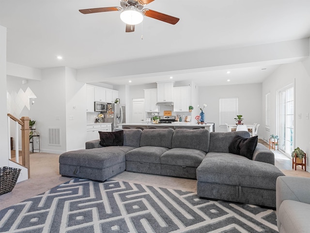 carpeted living room with ceiling fan