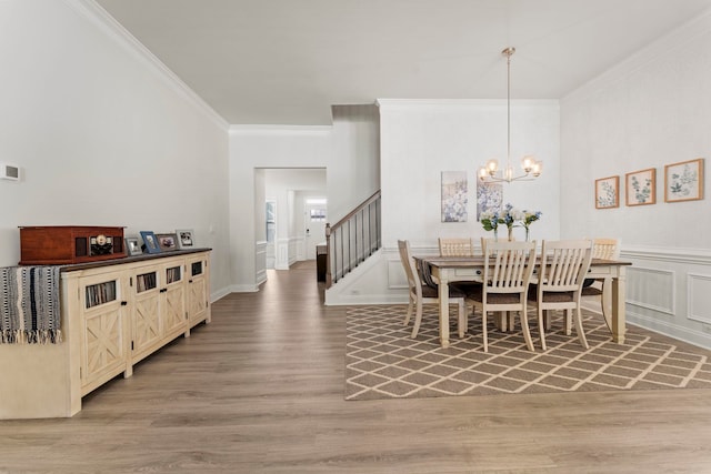 dining area featuring a notable chandelier, crown molding, and hardwood / wood-style floors