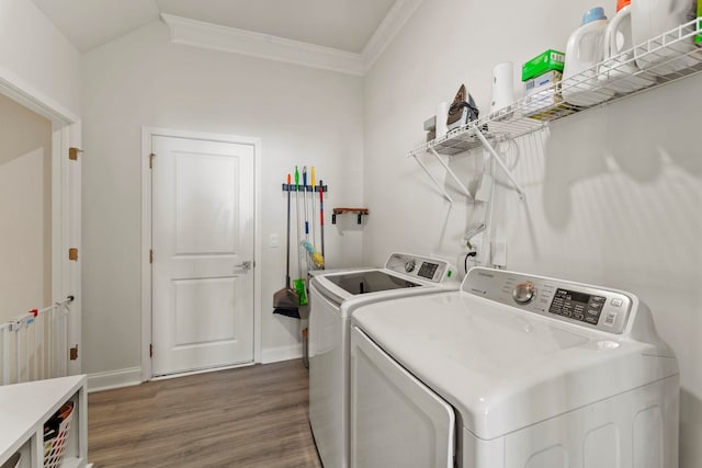 laundry room with dark hardwood / wood-style flooring, ornamental molding, and separate washer and dryer