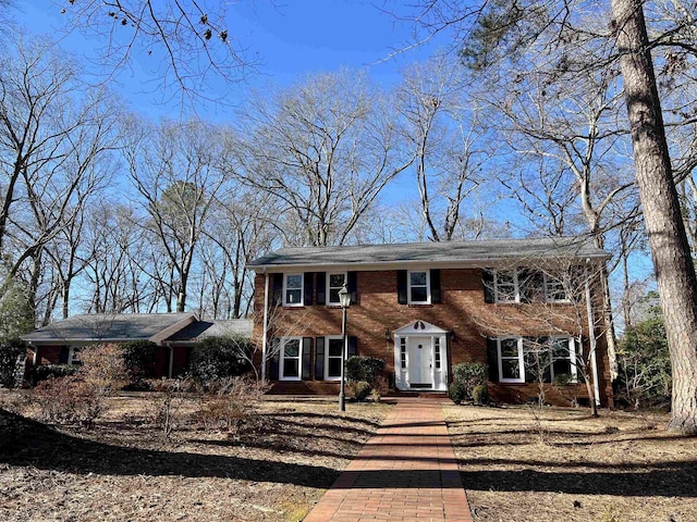 colonial house featuring brick siding