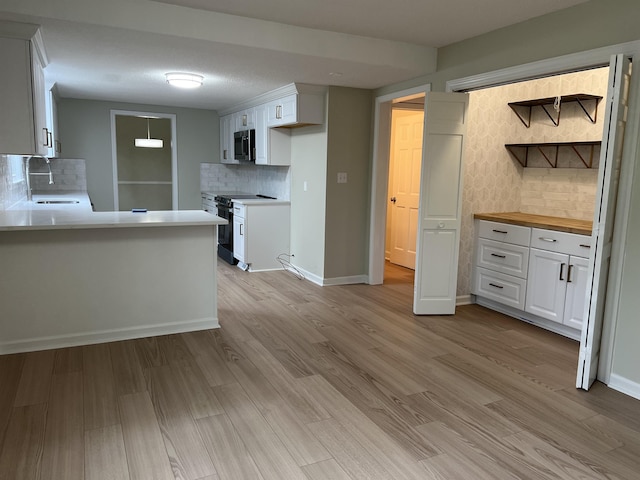 115 Fernbrook Cir, Spartanburg, SC 29307 - kitchen with black / electric stove, stainless steel microwave, light wood-style flooring, and white cabinetry