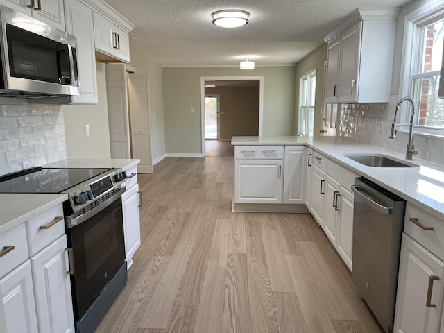 115 Fernbrook Cir, Spartanburg, SC 29307 - kitchen featuring stainless steel appliances, light countertops, light wood-style flooring, a sink, and a peninsula