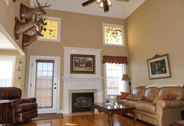 living room featuring hardwood / wood-style flooring, a towering ceiling, and ceiling fan