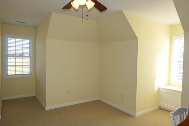 additional living space featuring ceiling fan and light carpet