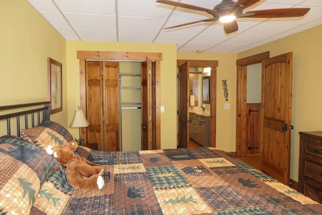 bedroom featuring ceiling fan, sink, and a paneled ceiling