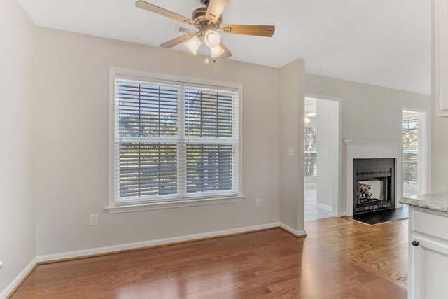 unfurnished living room with ceiling fan, plenty of natural light, and light hardwood / wood-style flooring