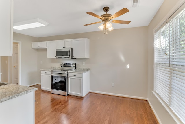 kitchen featuring ceiling fan, white cabinetry, appliances with stainless steel finishes, and light hardwood / wood-style flooring