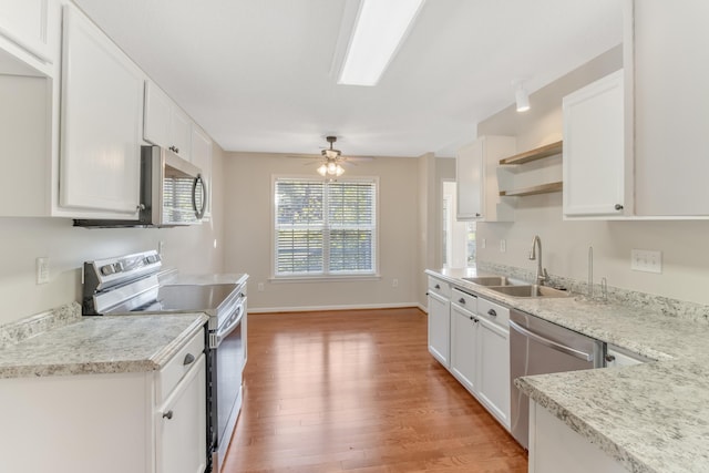 kitchen featuring wood-type flooring, white cabinetry, stainless steel appliances, sink, and ceiling fan