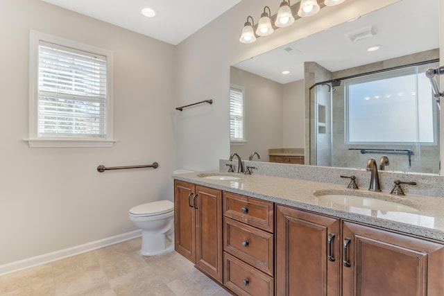 bathroom featuring a healthy amount of sunlight, toilet, walk in shower, and vanity