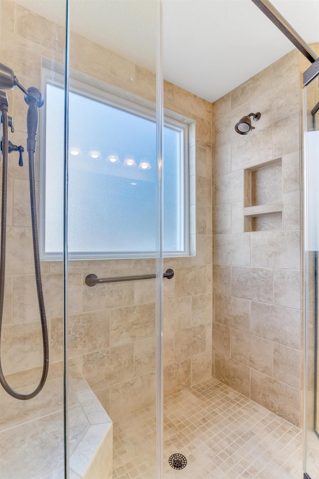 bathroom featuring a shower with door