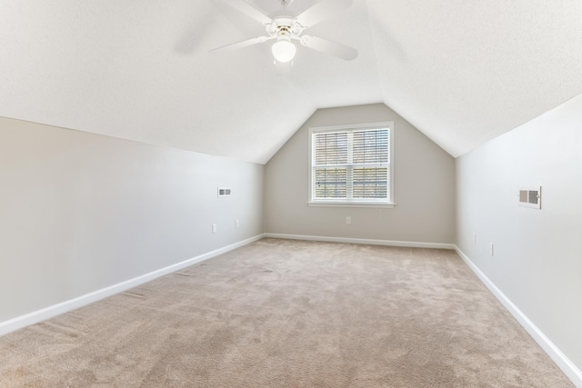 additional living space featuring vaulted ceiling, ceiling fan, and light carpet