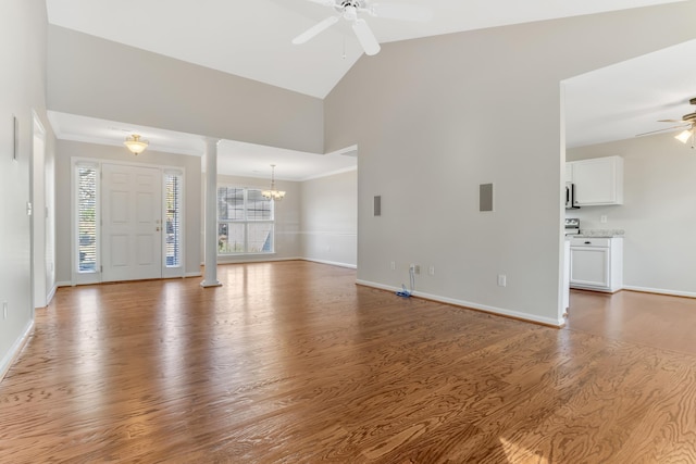 foyer with ornate columns, hardwood / wood-style floors, high vaulted ceiling, ornamental molding, and ceiling fan with notable chandelier