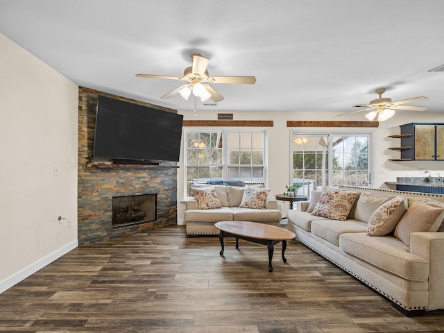 living room with dark hardwood / wood-style flooring, ceiling fan, and a fireplace