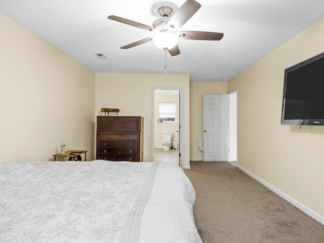 bedroom featuring light carpet, ensuite bath, and ceiling fan