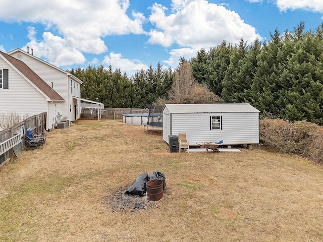 view of yard featuring central AC, a pool, and an outdoor structure