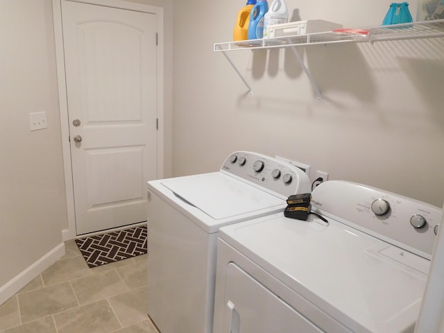 clothes washing area with washing machine and dryer and light tile patterned floors