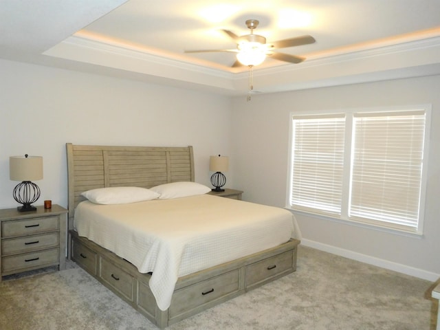 bedroom with light carpet, ornamental molding, ceiling fan, and a raised ceiling