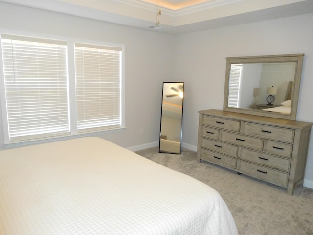 bedroom with light carpet, a tray ceiling, and crown molding